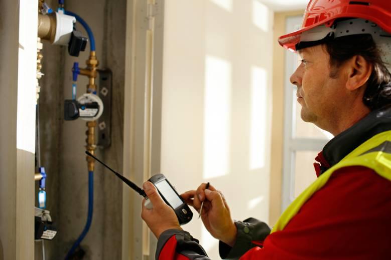 technicien de chez Veolia devant un compteur d'eau