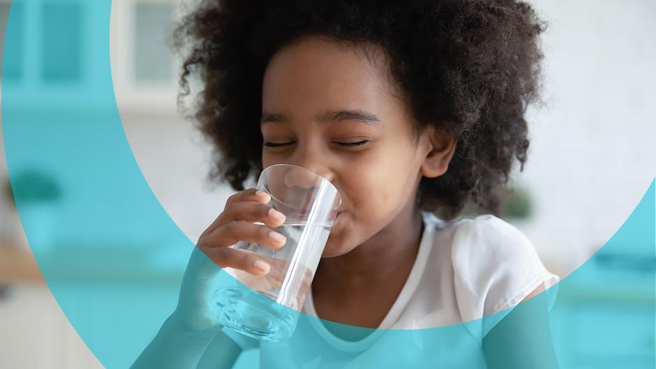 Little girl drinking a glass of water